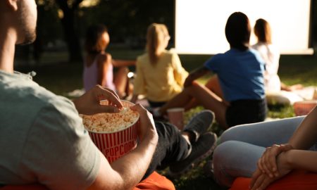 People Watching Movie with Popcorn Outside at Night