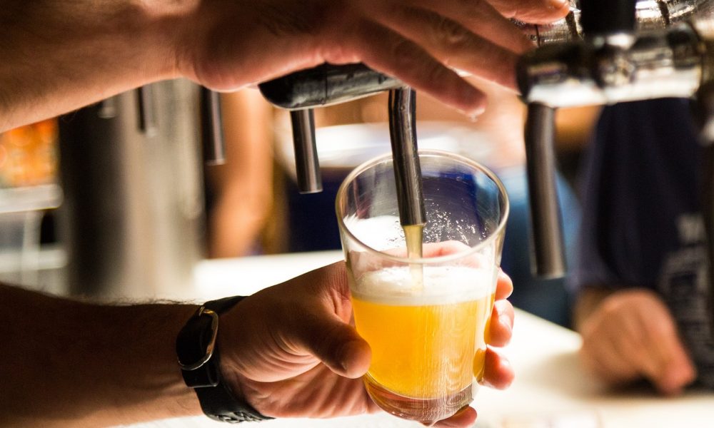 Man Holding Glass Cup Pouring Beer in Cup